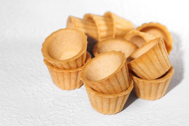 Homemade empty tartlets baskets of puff pastry, isolated on a white background.