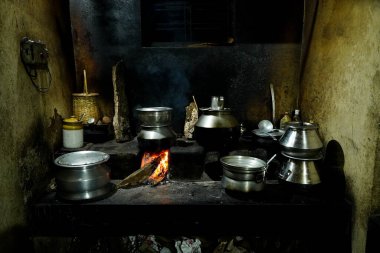 Food is prepared in an old village kitchen  with firewood  n Kerala with lot of utensils