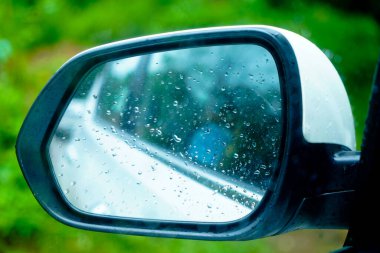 Rear view mirror of a car with rain drops, close up shot