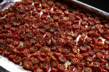 Sun dried tomatoes with fresh herbs and spices. Slate background. Step by step cooking. Top view.