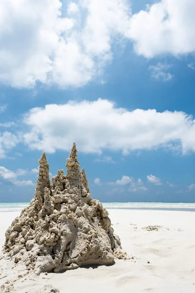 Sand castle on tropical white sand beach in Maldives. Holiday concept with sandcastle on sand castle on a background of blue sky.