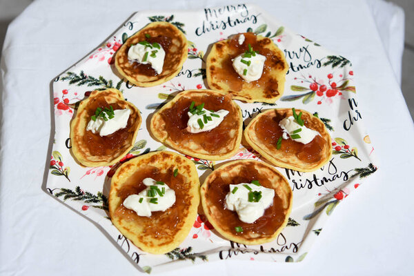 Italian finger food: polenta base with melted cheese, raw ham and pistachios