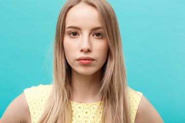 Temiz ciltli güzel bir genç kadın. Yüzüne dokunan güzellik mankeni portresi. Spa, cilt bakımı ve sağlık. Kapat, mavi arkaplan, kopyala.