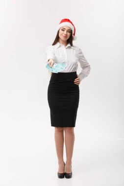 Noel ve Finansal Konsept - Genç kendine güvenen iş kadını önünde mutlu bir yüzle para gösteriyor.