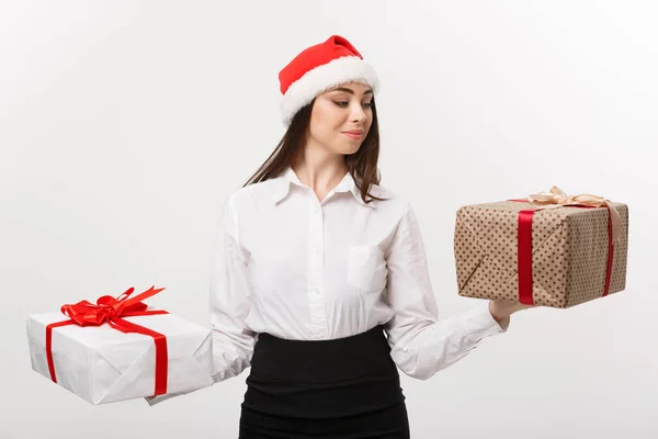 Conceito de Natal - jovem mulher de negócios caucasiana feliz com chapéu de Papai Noel escolher caixas de presente com espaço de cópia no lado . — Fotografia de Stock