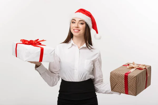 Conceito de Natal - jovem mulher de negócios caucasiana feliz com chapéu de Papai Noel escolher caixas de presente com espaço de cópia no lado . — Fotografia de Stock