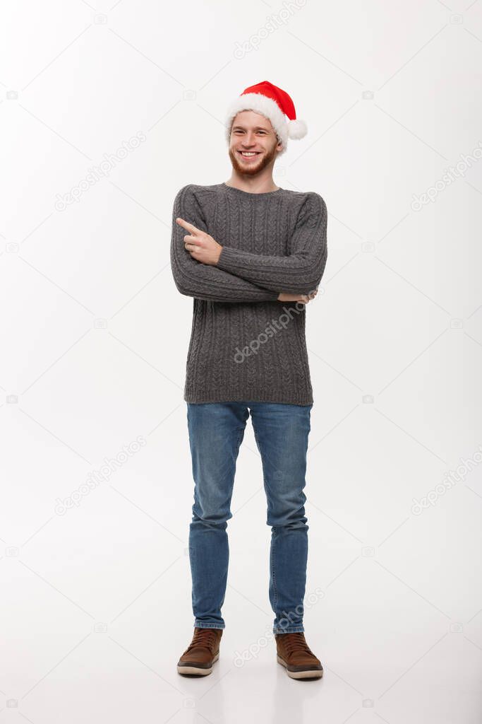 Holiday Concept - Young beard man in sweater enjoy playing and pointing finger onside with copyspace.