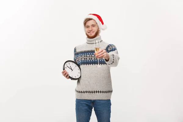 Holiday koncept - ung stilig skägg mannen i tröja med vit klocka och champagne över vita studio bakgrund. — Stockfoto