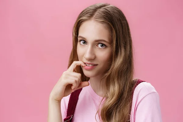 Linda chica femenina aprendiendo cómo hacer miradas y seducir a novio con mirada coqueta morder dedo sensualmente posando sobre fondo rosa, coqueteando haciendo senducing mirada usando maquillaje en la fecha — Foto de Stock