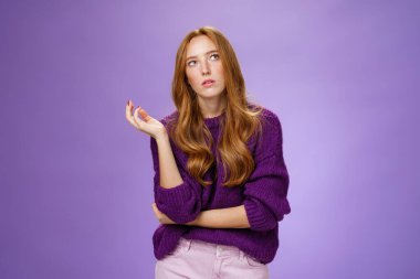 Olamaz, yine mi? Sinirli ve bıkkın kızıl saçlı kızın portresi, mor duvarın üstünde cezalandırılmaktan rahatsız olmuş gibi, avuç içi gibi iç çekiyor.