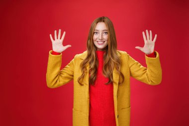 Sevimli ve cana yakın kızıl saçlı, mavi gözlü, şık sarı ceketli, çilli on numarayı gösteren ya da kırmızı arka planda mutlu bir şekilde gülümseyen bir düzine şey sipariş eden güzel bir kadın.