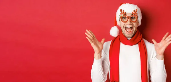 Noel, kış tatili ve kutlama kavramı. Şaşırmış ve mutlu bir adamın görüntüsü. Şaşırmış görünüyor. Parti gözlüğü takıyor ve yeni yılın tadını çıkarıyor. — Stok fotoğraf
