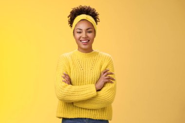 Ciddi, güçlü, güzel görünüşlü, gülümseyen, Afro-Amerikan kadın feminist blogcu el ele tutuşan, kendinden emin, sırıtan, çalışma sürecini zevkle izleyen, sarı arka planda duran biri.