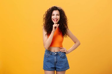 Senin için bir şeyim var. Kıvırcık saçlı, kısa şortlu, etkileyici Avrupalı genç bir kadının portresi. Geniş gülümsemeli, sessiz bir jest yapıyor ve sürpriz hazırlıyor.