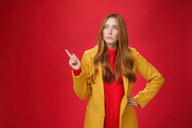 Üzgün ve kasvetli, 20 'li yaşlarda, sarı ceketli, beline sarılan, somurtan, sol üst köşeye bakan, pişmanlık ve kederle bakan bir kız.