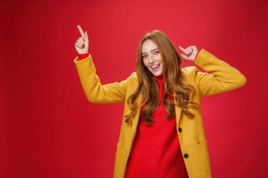 Bütün gece dans ettin. Neşeli ve heyecanlı kızıl kızın portresi mutlu ve keyifli bir gün gibi geliyor. Disko hareketleriyle müziğin ritmine ayak uyduruyor ve kameraya gülümsüyor.