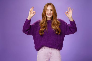 Her şey yolunda. Çekici ve mutlu genç kızıl saçlı, uzun güzel saçları ve çilleri olan neşeli bir şekilde gülümseyen ve el kaldırarak iyi hareketler yapan, her şeyin mükemmel olduğunu onaylayan.