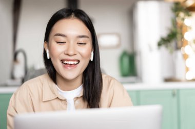 Bilgisayarda konuşan mutlu gülümseyen Asyalı kız, video konferansı. Çevrimiçi webinar eğitimi alan öğrenci, uzaktan eğitim alıyor.
