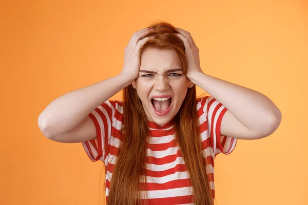 Pissed fed up redhead female teenager annoyed, break down, grab head yelling hateful displeased, depressed, upset failure, stand angry disappointed, panic, shouting aggressive orange background — Foto de Stock