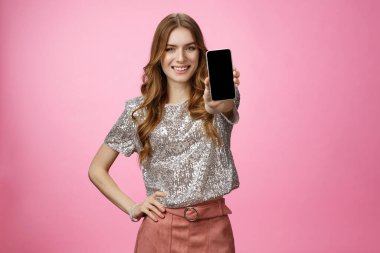 Stüdyo kendine güvenen karizmatik genç cazibeli kadın cep telefonu ekranını gösteren harika bir akıllı telefon uygulaması tanıt kendine güvenen tavsiye blogger sayfasını takip et, pembe arka planda dur