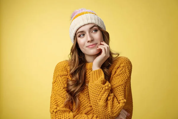Ονειρεμένη δημιουργική γοητευτική κοπέλα φορώντας ζεστό καπέλο πουλόβερ ατενίζοντας δεξιά στοχαστική απεικόνιση ρομαντική ημερομηνία χαμογελώντας ευτυχισμένη εικόνα ανακαλώντας υπέροχες αναμνήσεις, στέκεται ευτυχής κίτρινο φόντο — Φωτογραφία Αρχείου