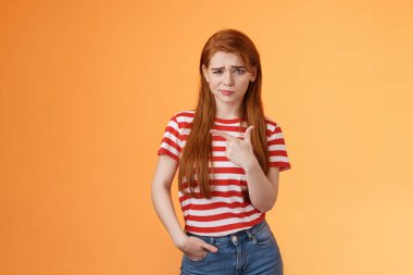Rahatsız edici sevimli kızıl saçlar, uzun doğal kızıl saçlar, sırıtan bir tereddüt, şikayet, şüpheli ve şüpheli görünen sol nokta, ürünün gerçekten iyi olup olmadığından emin değilim, emin değilim, turuncu arka plan