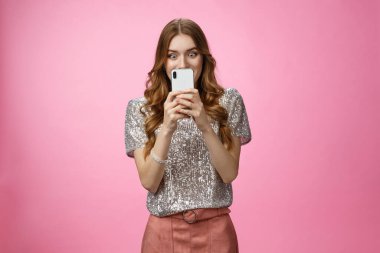 İlginç görünüşlü, şık Avrupalı çekici kadın internetten alışveriş yapıyor. Heyecanlı görünüyor. Akıllı telefon ekranı harika bir satış promosyonu buluyor.