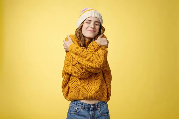 Upbeat encantador alegre jovem mulher sentindo-se feliz sorte abraçando-se como novo suéter confortável quente inclinação cabeça ombro fechar os olhos sorrindo amplamente abraçando o próprio corpo, fundo amarelo — Fotografia de Stock