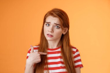 Masum, çekingen, kırgın, incinmiş, kırgın bir kız. Üzücü suçlamalar duyuyor, kaşlarını çatıyor, rencide olmuş, asık suratlı, huzursuz turuncu arka planda duruyor.