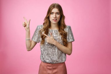 Dağılmış, güvensiz, kendine güveni olmayan, çekici, genç, çekici kız giyinme partisi hayal kırıklığına uğramış, hoşnutsuz, tiksindirici, tiksindirici, sorgulanmış, pembe arka plan ile ilgili.