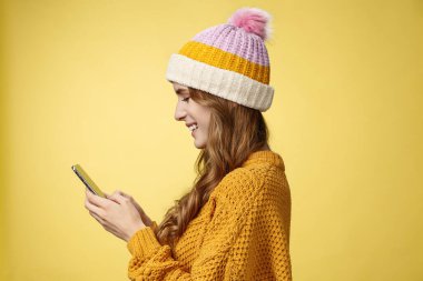 Profil, sempatik, rahat, çağdaş genç bir kızı elinde akıllı telefonuyla gülümseyerek mesajlaşırken, eğlenceli bir kurgu resmi görüntülerken çekti. İnternet 'te blogcu mesajlaşmacı takipçileri