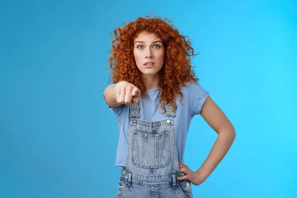 You seem familiar. Worried concerned lively redhead emotive curly girl pointing camera look excited nervously recognize someone standing confused hold hand waist wear overalls — Stock Photo, Image