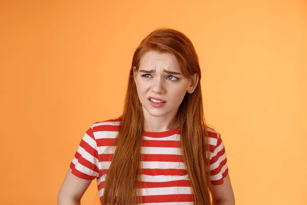 Close-up unsure redhead teenager frowning uncertain, having doubts, look perplexed left side copy space, hesitating, cringe dislike and disappointment, stare frustrated, uneasy decision — Stock Photo, Image