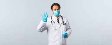 Covid-19, virüsü önleme, sağlık çalışanları ve aşı konsepti. Klinikteki profesyonel doktor, tıbbi maske ve eldiven takarak sağlığını enfeksiyondan korumak için dört adım açıkladı.