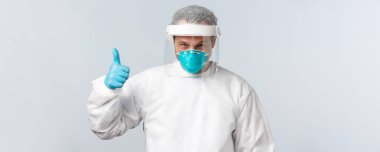 Covid-19, virüs, sağlık çalışanları ve aşı konsepti. Koruyucu ekipman ve medikal solunum cihazlarında kararlı ve kendine güvenen bir doktor hasta üzerinde çalışmaya hazır olduğunu gösteriyor.