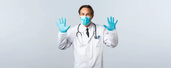 Covid-19, prevenção de vírus, profissionais de saúde e conceito de vacinação. Médico excitado de casaco branco, máscara médica e luvas mostrando as mãos, número dez — Fotografia de Stock