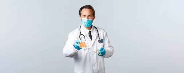 Covid-19, Prävention von Viren, Gesundheitspersonal und Impfkonzept. Professioneller Arzt in medizinischer Maske und Handschuhen gibt Patienten verschriebene Medikamente, Arzt gibt Tabletten — Stockfoto