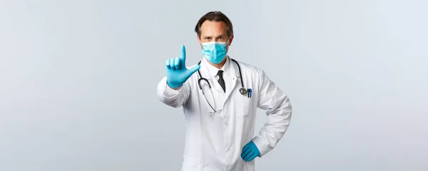 Covid-19: 바이러스 예방, 의료 종사자 및 예방 개념. 의료용 마스크와 장갑을 끼고, 손가락을 마구 흔들고, 코로나 바이러스를 가진 환자들을 금지하거나 경고하는 의사 — 스톡 사진