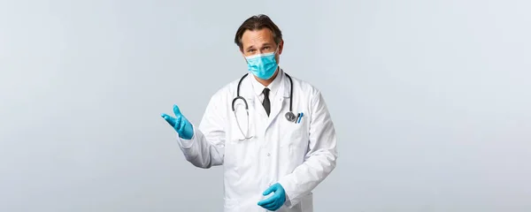 Covid-19: 바이러스 예방, 의료 종사자 및 예방 개념. 의료용 마스크와 장갑을 낀 진지 해 보이는 의사는 코로나 바이러스가 유행하는 동안 환자와 대화를 나누며 이에 대해 설명 했다. — 스톡 사진