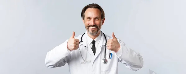 Covid-19: 바이러스 예방, 의료 종사자 및 예방 개념. 하얀 코트를 입고 행복 한 미소를 짓고 손을 들고 승인을 받은 의사는 품질을 추천하고 보증 한다 — 스톡 사진