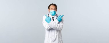 Covid-19, virüsü önleme, sağlık çalışanları ve aşı konsepti. Tıbbi maskeli, eldivenli, parmaklarını yana doğru gösteren kararsız ve kafası karışık bir doktor seçiminde yardıma ihtiyaç duyar.