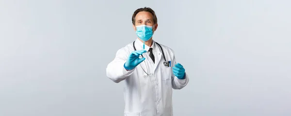 Covid-19: 바이러스 예방, 의료 종사자 및 예방 개념. 의료용 마스크를 쓴 중년의 의사와 코로나 바이러스 백신이나 히프 준비, 환자를 위한 주사 준비 — 스톡 사진