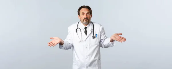 Covid-19, coronavirus outbreak, 의료 종사자와 전염병 컨셉트. 턱수염이 없고 결단력이 없는 흰옷을 입고 거추장거리며 난처 한 대답을 하는 남자 의사, 아무도 모른다 — 스톡 사진