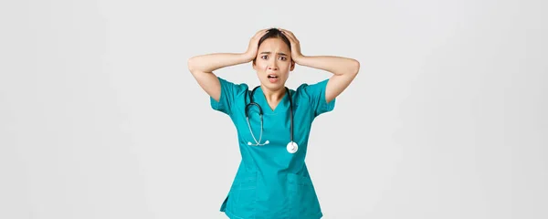 Covid-19, pracownicy służby zdrowia i zapobieganie koncepcji wirusa. Zdenerwowana i pod presją azjatycka pielęgniarka, stażystka chwyta się głowy w panice i grymas, czując niepokój, mają duży problem — Zdjęcie stockowe