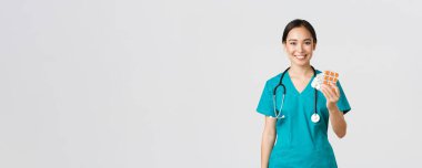Sağlık çalışanları, virüsü önleme, karantina kampanyası konsepti. Dost canlısı bayan Asyalı hemşire, doktor hasta ilaç reçetesini açıkla, uyuşturucu gösteriyor ve gülümsüyor, beyaz arkaplan