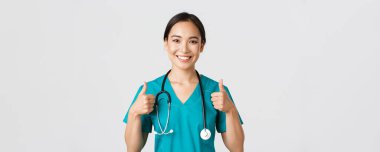 Sağlık çalışanları, virüsü önleme, karantina kampanyası konsepti. Neşeli gülümseyen Asyalı doktor, kendine güvenen doktor, hastayı sağlama al, onayını ver.