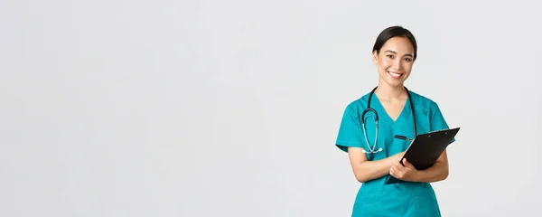 医療従事者ウイルスの予防隔離キャンペーンの概念。陽気フレンドリーなアジアの女性医師,毎日の検査中にクリップボードを持つ医師,立って白い背景 — ストック写真