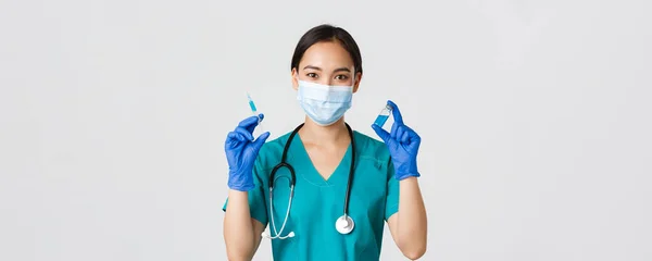 Covid-19, onemocnění koronavirem, koncept zdravotnických pracovníků. Detailní záběr roztomilé usmívající se asijské sestřičky, lékař ukazující ampuli a injekční stříkačku, připravit na injekci, bílé pozadí — Stock fotografie
