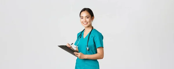 医療従事者ウイルスの予防隔離キャンペーンの概念。笑顔フレンドリーな女性医師,爪の看護師は、クリップボードでドーン結果分析を書きます,立って白い背景 — ストック写真