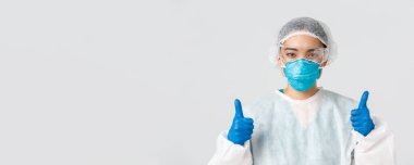 Covid-19, koronavirüs hastalığı, sağlık çalışanları konsepti. Kendine güvenen profesyonel Asyalı doktor, teknoloji laboratuarı çalışanı kişisel koruma ekipmanları onaylandı.
